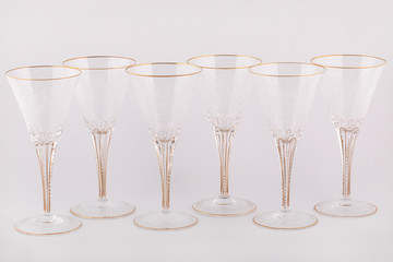 Stemware faceted glasses made of Czech glass with a Golden lines and patterns isolated on a white background.