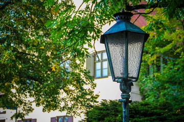 Old bronze street lamp on the street of a European city