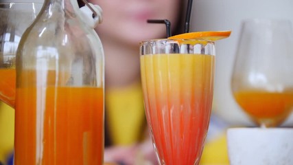 A restaurant food. A drink with orange on top of the glass. A light dish on a plate