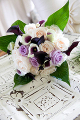 a purple and white bouquet of wedding flowers waiting for a bride