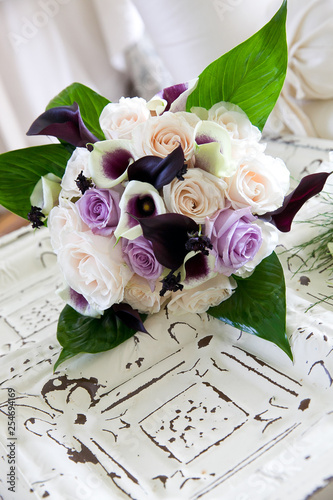 a purple and white bouquet of wedding flowers waiting for a bride