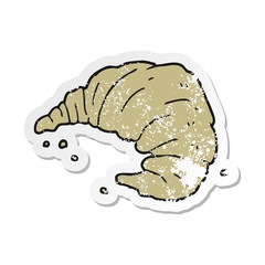 retro distressed sticker of a cartoon croissant