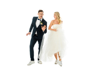 happy couple dancing in elegant clothes and sneakers isolated on white