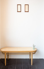 Vintage rattan chair with picture frame on the empty wall background.