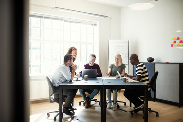 Designers discussing work during a meeting in an office