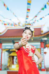 A beautiful asian girl wearing a red suit showing her gestures and smiling makes her look happy.