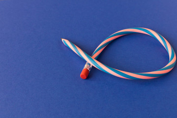 Flexible pencil . Isolated on blue background. Bending pencil. Selective focus.