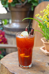 Iced tea with lemon slices and dried chilli  on glass of cup on wood background