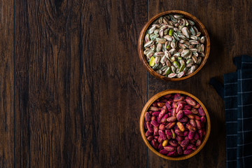Raw and Roasted Wooden Bowl of Peeled Pistachios without Shell / with No Shell