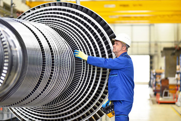 workers manufacturing steam turbines in an industrial factory