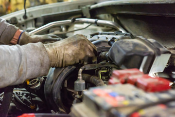 A mechanic checks the engine.