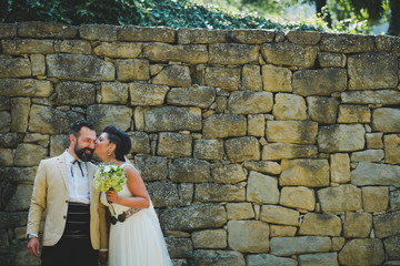 Wedding couple in front of stone wall