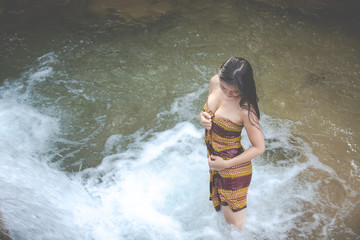 Happy bathing women at the natural waterfall.