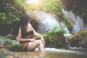 Happy bathing women at the natural waterfall.
