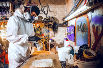 Master painter in a factory - industrial painting wood with spray gun.