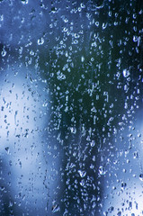 Rain drops on window glasses surface with bokeh background.