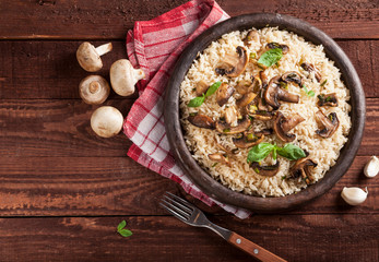 Cooked white rice with mushroomsin a bowl on wooden background.