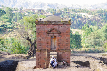 Lalibela, Amhara Region, Ethiopia - Jan 14, 2014: Priest with the holy book in hands sitting on the steps of the Selassie Chapel.
