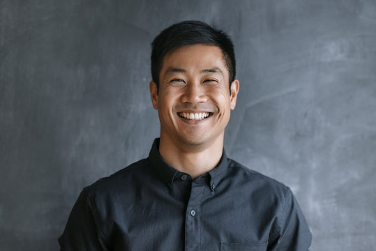 Energetic Asian Businessman Standing By A Blank Office Chalkboard