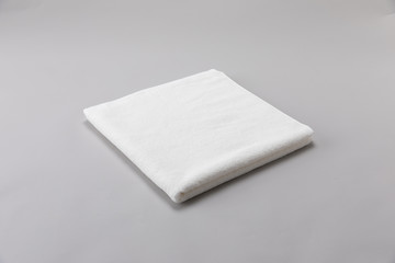 White single towel folded on gray background