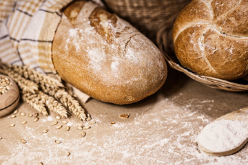 Freshly baked bread, wheat and flour on a rustic background
