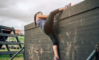 Participant in obstacle course climbing wall