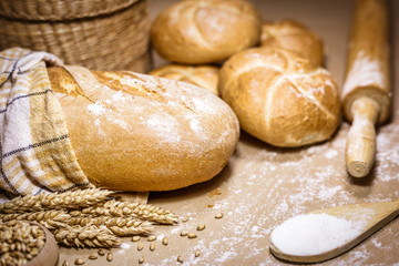 Freshly baked bread, wheat and flour on a rustic background