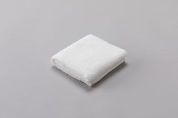 Fototapeta na wymiar White single towel folded on gray background