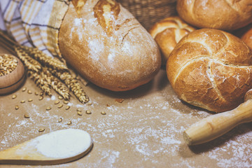 Freshly baked bread, wheat and flour on a rustic background