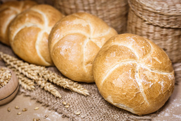 Fresh bread and wheat on a rustic background