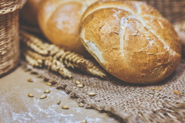 Fresh bread and wheat on a rustic background