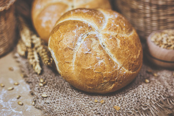 Fresh bread and wheat on a rustic background
