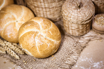 Fresh bread and wheat on a rustic background
