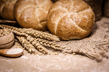 Freshly baked bread, wheat and flour on a rustic background