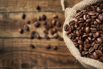 Ziarna kawy w jutowym worku na starych deskach © piotrszczepanek