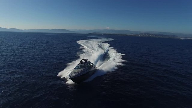 Aerial view of a luxury yacht slaloming at full speed.