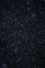 Artificial snow falling on a black background as overlay