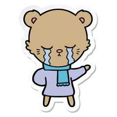 sticker of a crying cartoon bear wearing winter clothes