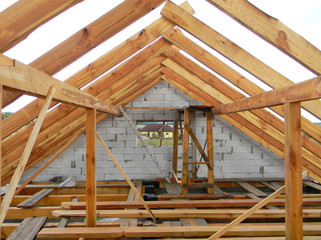 Unfinished attic house roofing construction trusses, wooden beams, eaves, timber.  House roof wooden frame construction.