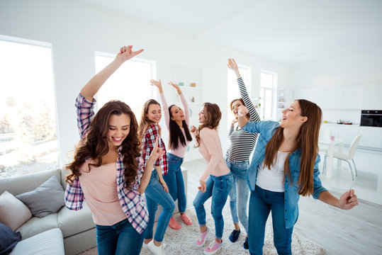 Nice-looking lovely cool charming attractive cheerful glad crazy dreamy optimistic girls wearing casual clothes raising hands up having fun in light white interior room house indoors