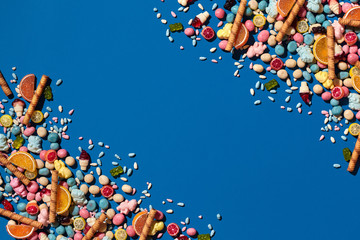 Photo of dragee candies placed on the opposite corners of image with a copy space in the middle