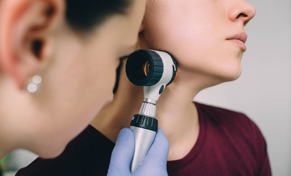 dermatologist exam patient's skin using dermatoscope