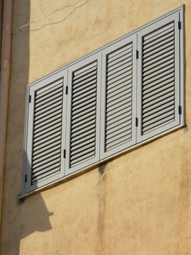 Closed grey shutters on a building exterior