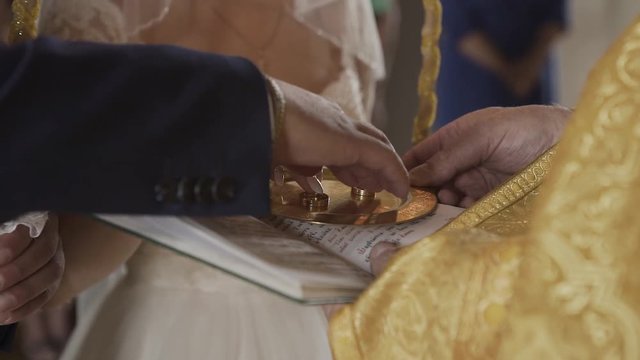 the priest conducts the wedding ceremony, serves wedding rings.