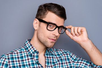 Close-up portrait of nice handsome attractive guy wearing checked shirt touching glasses isolated over gray pastel background