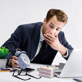 Busy businessman looking at alarm clock