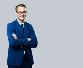 young businessman in glasses, against grey