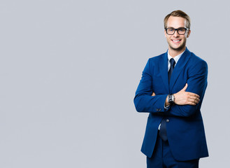 young businessman in glasses, against grey