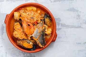portuguese fish and seafood stew in dish on ceramic background
