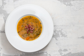 soup with smoked meat in white plate on ceramic dish